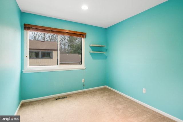 carpeted empty room with baseboards, visible vents, and recessed lighting