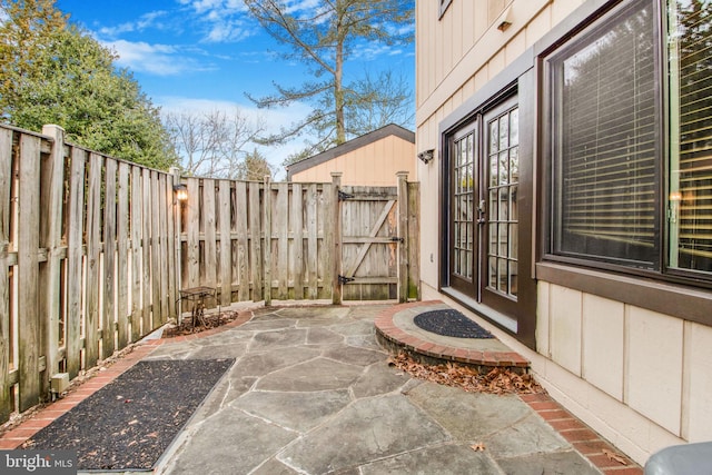 view of patio with french doors, a fenced backyard, and a gate