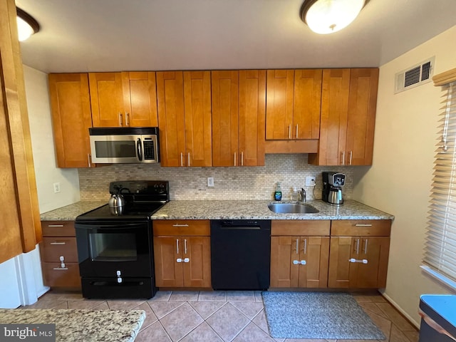 kitchen featuring a sink, visible vents, decorative backsplash, black appliances, and brown cabinetry