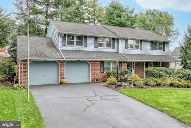 view of front of house with a front yard, a garage, and central AC unit