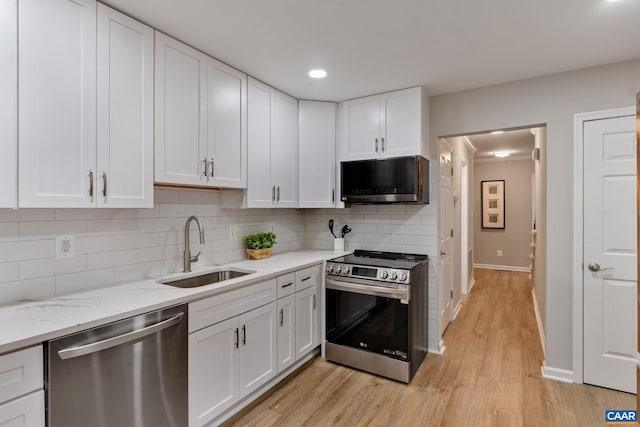 kitchen featuring tasteful backsplash, appliances with stainless steel finishes, sink, light wood-type flooring, and white cabinetry