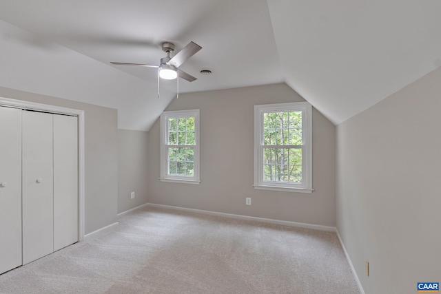 additional living space with light carpet, lofted ceiling, and ceiling fan