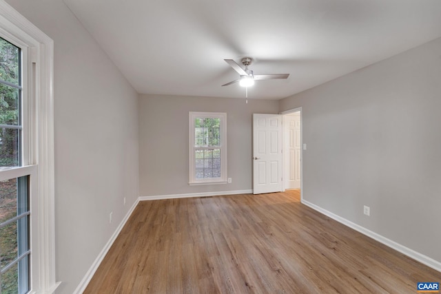 unfurnished room featuring ceiling fan, light wood-type flooring, and plenty of natural light