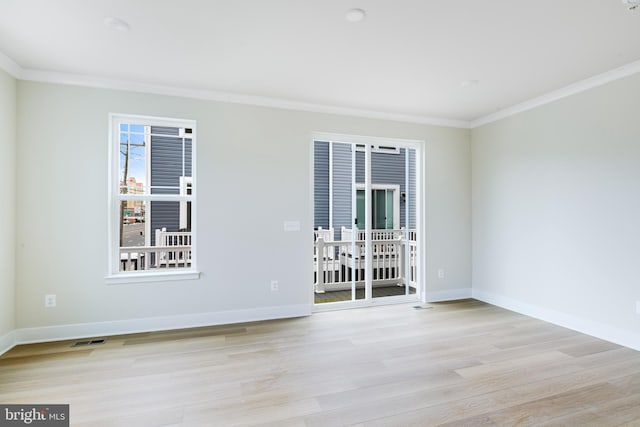 unfurnished room with ornamental molding and light wood-type flooring