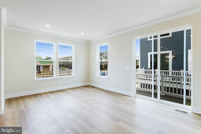 empty room with ornamental molding and light hardwood / wood-style flooring