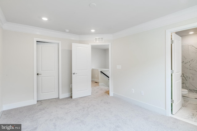 unfurnished bedroom with ensuite bath, light colored carpet, and crown molding