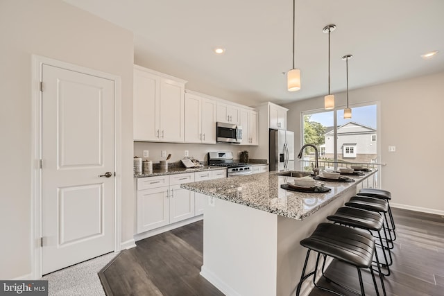 kitchen featuring white cabinets, a center island with sink, and stainless steel appliances