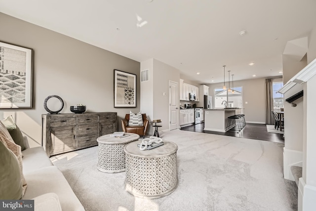 carpeted living room with sink