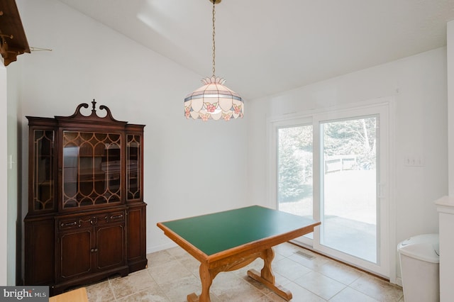 dining area with lofted ceiling and light tile patterned floors