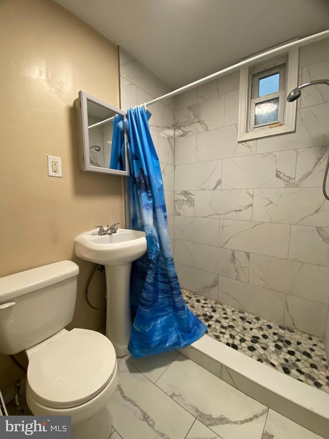 bathroom featuring toilet and curtained shower