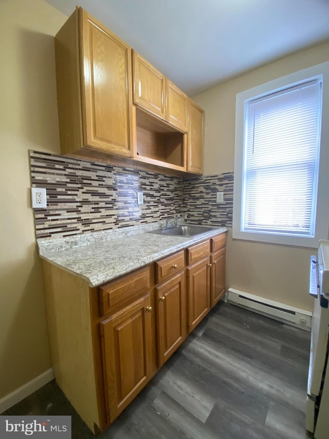 kitchen with tasteful backsplash, light stone countertops, a baseboard radiator, dark hardwood / wood-style floors, and sink