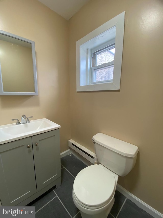 bathroom featuring tile patterned flooring, vanity, toilet, and a baseboard heating unit