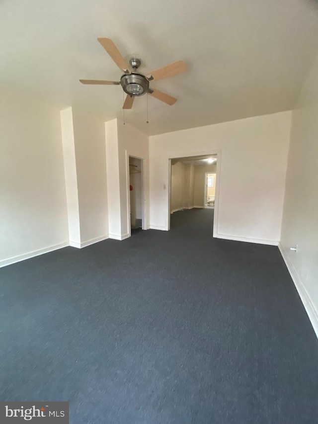 unfurnished bedroom featuring dark colored carpet and ceiling fan