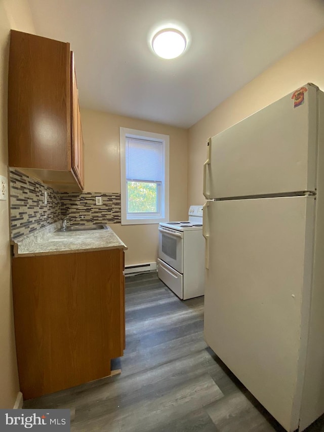 kitchen featuring a baseboard heating unit, tasteful backsplash, dark wood-type flooring, sink, and white appliances