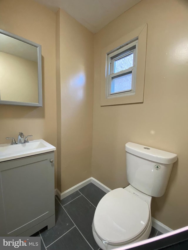 bathroom featuring tile patterned flooring, vanity, and toilet