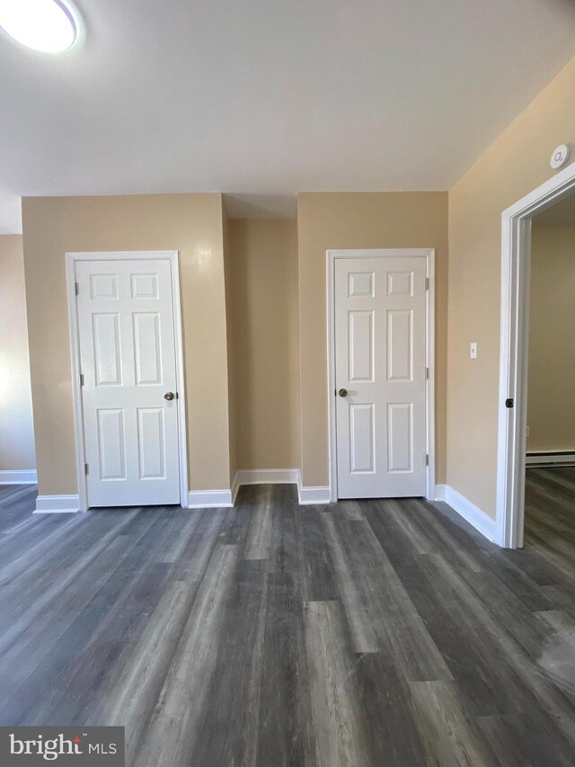 interior space with dark wood-type flooring and a baseboard radiator