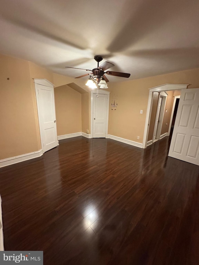 unfurnished bedroom with ceiling fan and dark wood-type flooring