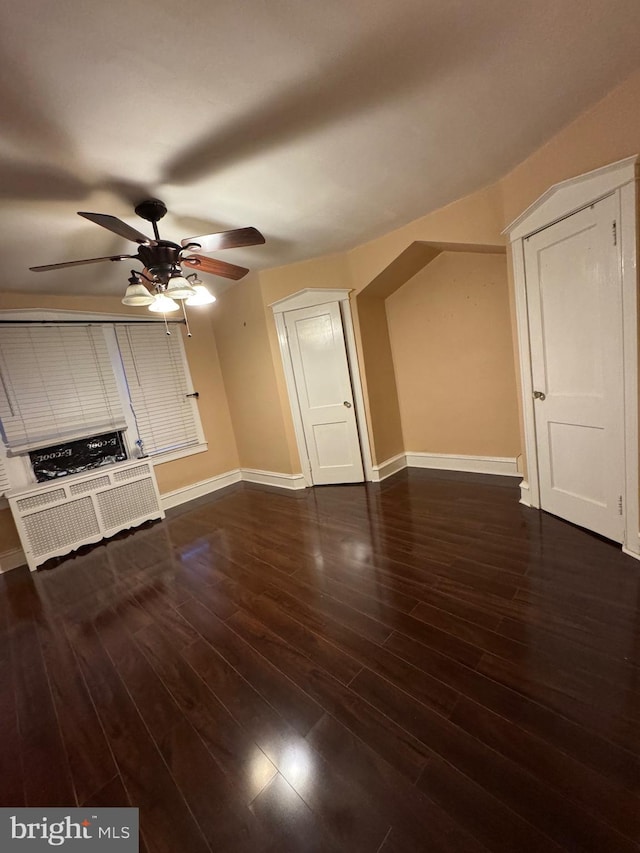 interior space with ceiling fan and dark hardwood / wood-style flooring