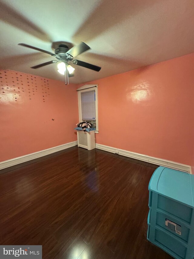 unfurnished room featuring ceiling fan and dark wood-type flooring