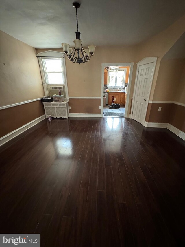 unfurnished dining area with cooling unit, dark hardwood / wood-style flooring, and a notable chandelier