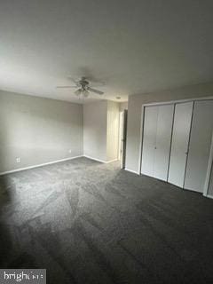 unfurnished bedroom with dark colored carpet, ceiling fan, and a closet