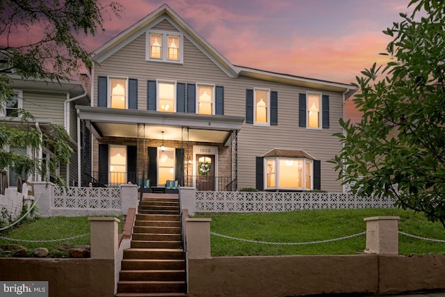 view of front of house featuring a lawn and covered porch