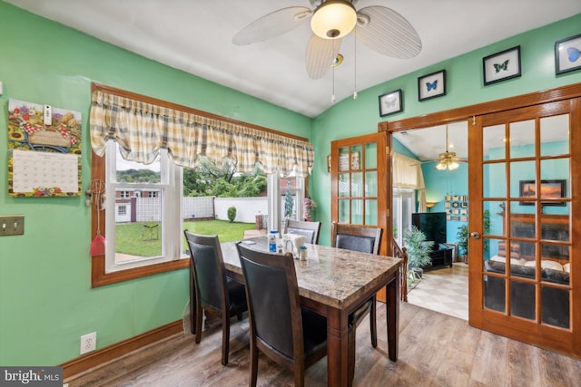 dining area featuring vaulted ceiling, hardwood / wood-style floors, ceiling fan, and french doors