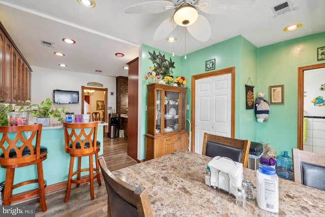 dining space with ceiling fan and hardwood / wood-style flooring