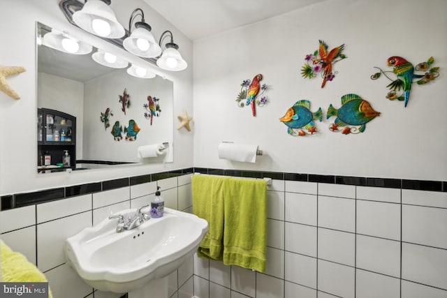 bathroom featuring tile walls and sink