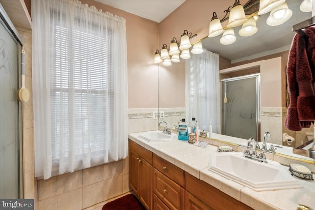 bathroom featuring vanity, tile walls, tile patterned flooring, and an enclosed shower