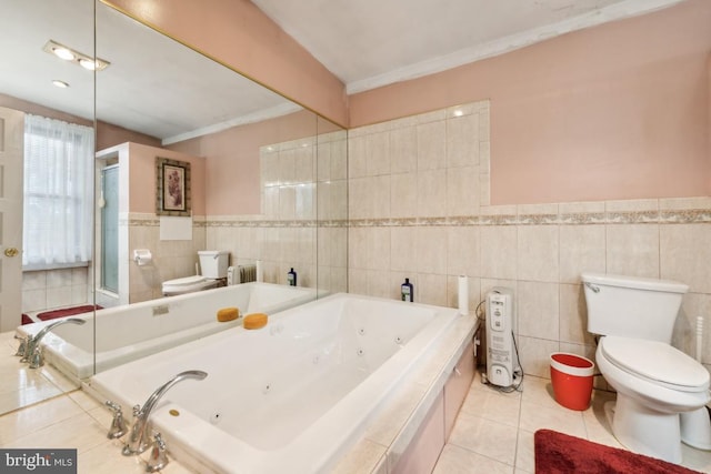 bathroom with tiled bath, tile walls, toilet, and tile patterned floors