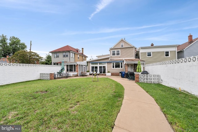 rear view of house featuring a lawn