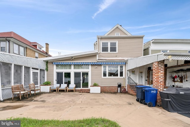 rear view of house featuring a sunroom and a patio