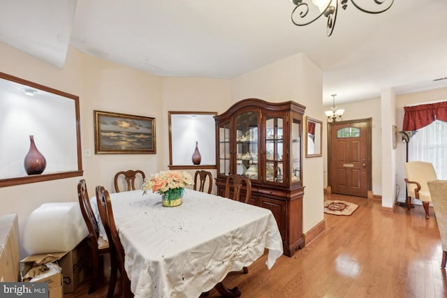 dining room with a notable chandelier and light wood-type flooring