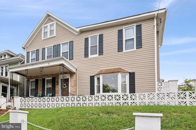 view of front of home with a front yard and a porch