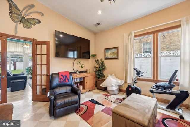 living room with vaulted ceiling, french doors, and plenty of natural light