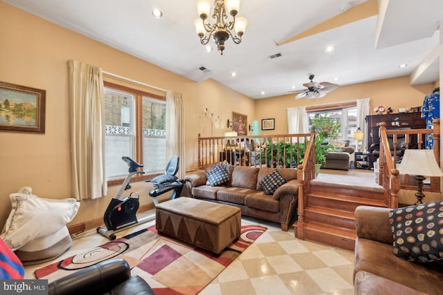 living room featuring ceiling fan with notable chandelier