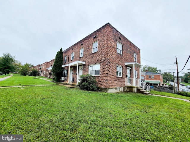view of front of property with a front lawn, fence, and brick siding