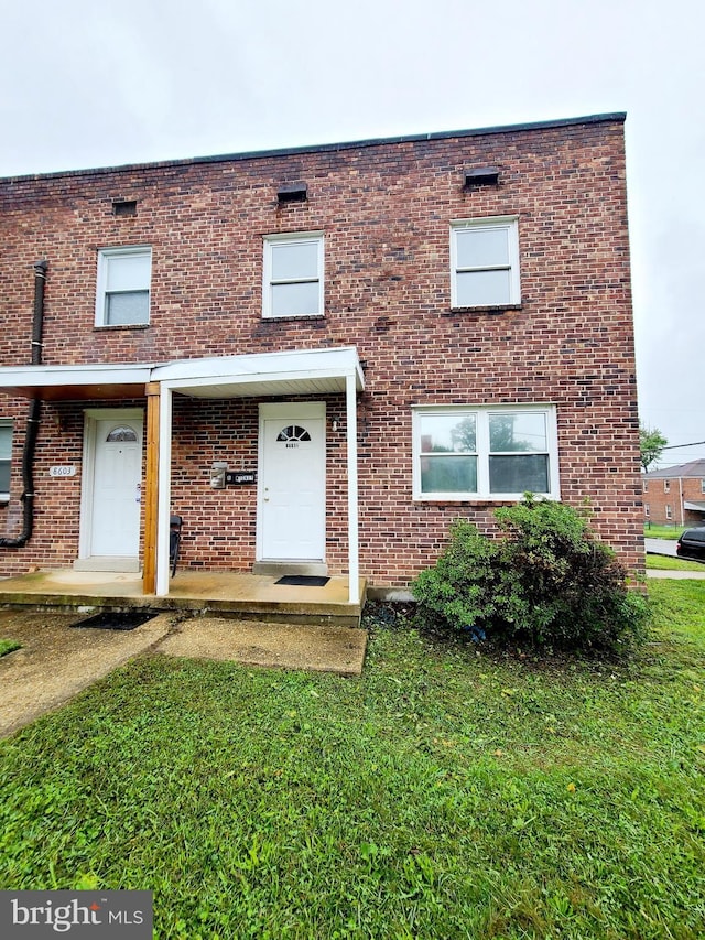 multi unit property with brick siding and a front lawn