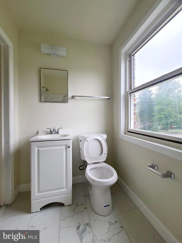 bathroom featuring marble finish floor, baseboards, toilet, and vanity