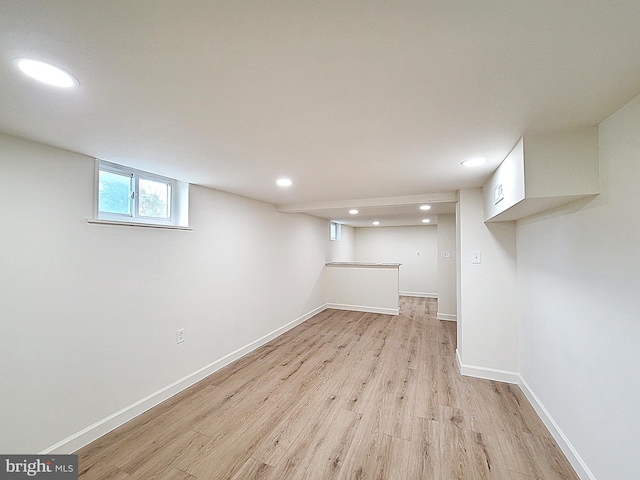 below grade area with baseboards, light wood-style flooring, and recessed lighting