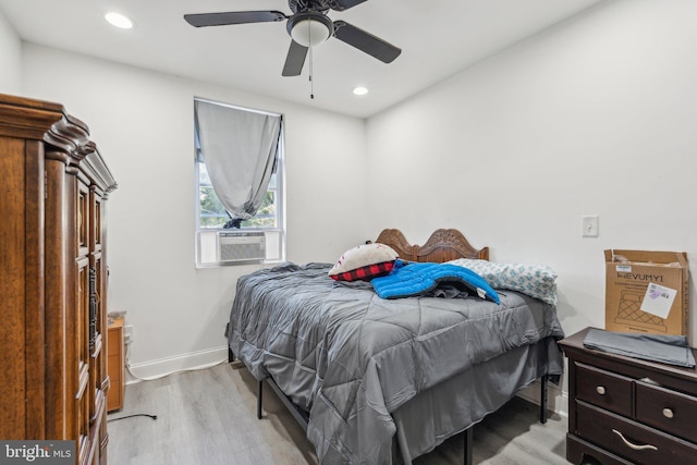 bedroom featuring ceiling fan, cooling unit, and light hardwood / wood-style flooring