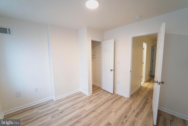 unfurnished bedroom with light hardwood / wood-style flooring and a closet