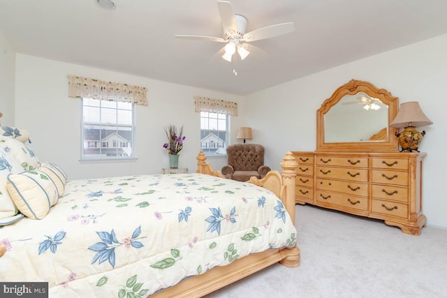 bedroom featuring multiple windows, light carpet, and ceiling fan