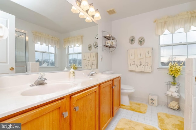 bathroom featuring tile patterned floors, vanity, toilet, and a shower with door