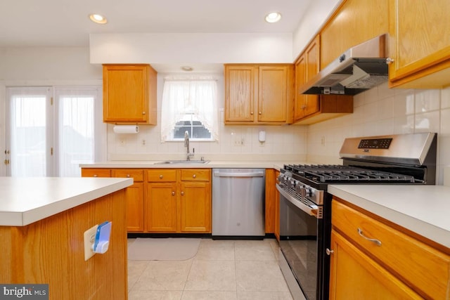 kitchen featuring sink, backsplash, stainless steel appliances, and light tile patterned flooring