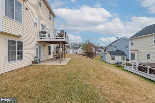 view of yard with an outbuilding, a wooden deck, and a patio area