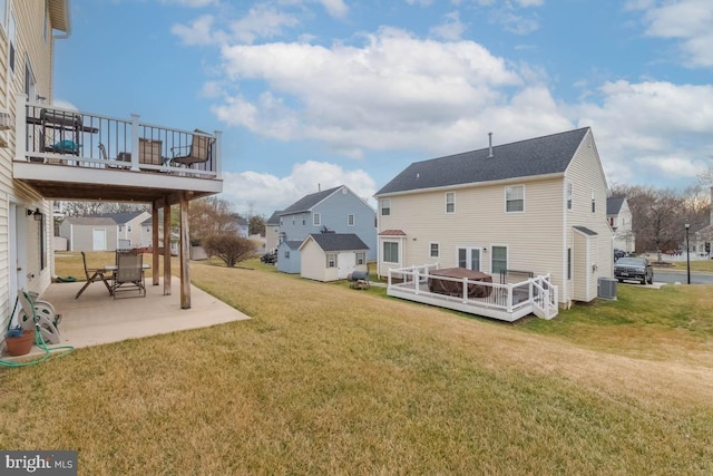 back of property featuring a wooden deck, a patio, central AC, and a lawn