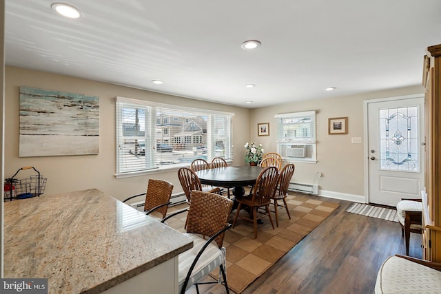 dining space with wood-type flooring, cooling unit, and a baseboard radiator