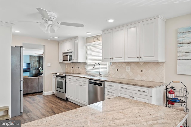 kitchen with ceiling fan, stainless steel appliances, sink, and white cabinetry